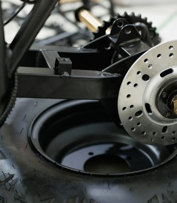 Workers are making a motorcycle in workshop. Preparing the motorcycle for sale. Wheel replacement